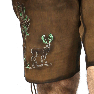 Close-up of a brown leather lederhosen leg featuring green antlered deer embroidery and swirling vine patterns