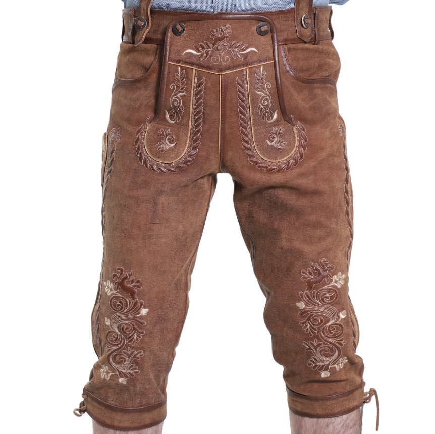 Front view of rustic oak Bavarian bundhosen showcasing bold, symmetrical embroidery on the flap and thighs, with braided accents and leather suspenders.