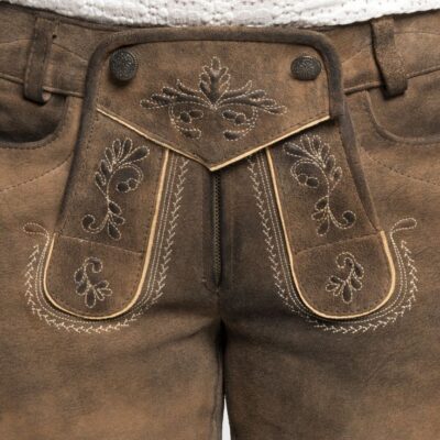Close-up of the front flap of women’s vintage brown Bavarian lederhosen shorts highlighting intricate beige embroidery and horn-style buttons.