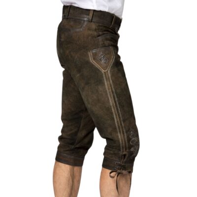 Angled side view of traditional deep walnut lederhosen with contrast-stitched side pocket flap and vertical embroidery running down the outer thigh.