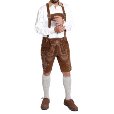 Full view of a man wearing a complete Bavarian lederhosen outfit, including a white shirt, brown embroidered shorts with suspenders, calf socks, and brown shoes.