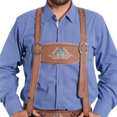 Close-up of brown leather suspenders over a blue shirt, with a chest strap featuring floral embroidery and silver buckles.