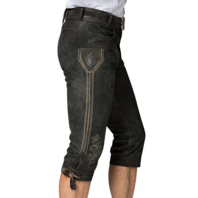 Side view of deep forest Bavarian bundhosen showing stylized embroidery on the pocket flap and along the outer thigh, paired with rustic suede finish.
