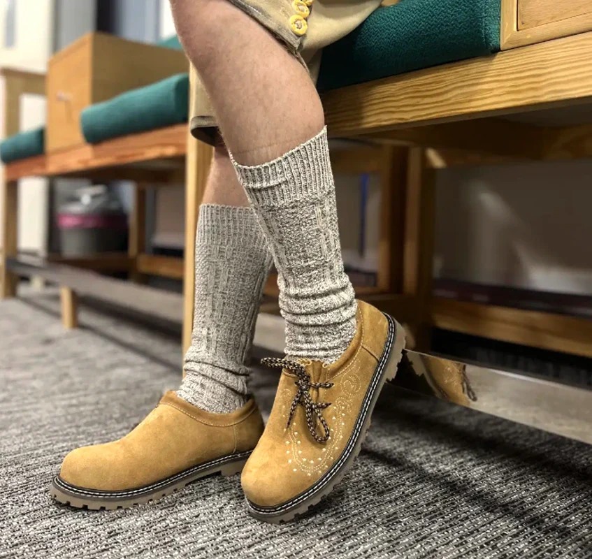 Close-up of traditional Bavarian Haferlschuhe paired with wool socks and lederhosen