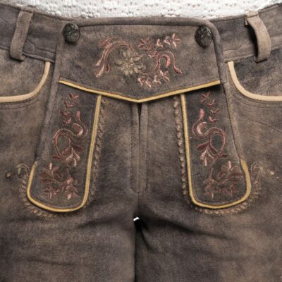Close-up view of front bib embroidery on ash brown Lederhosen with pink floral detailing and decorative buttons