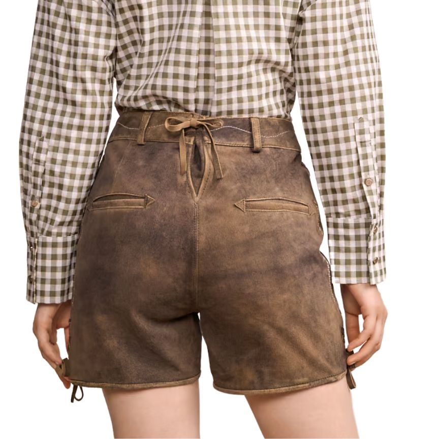 Back view of beige women’s suede lederhosen shorts with a plain design and belt loops, styled with a mauve top.