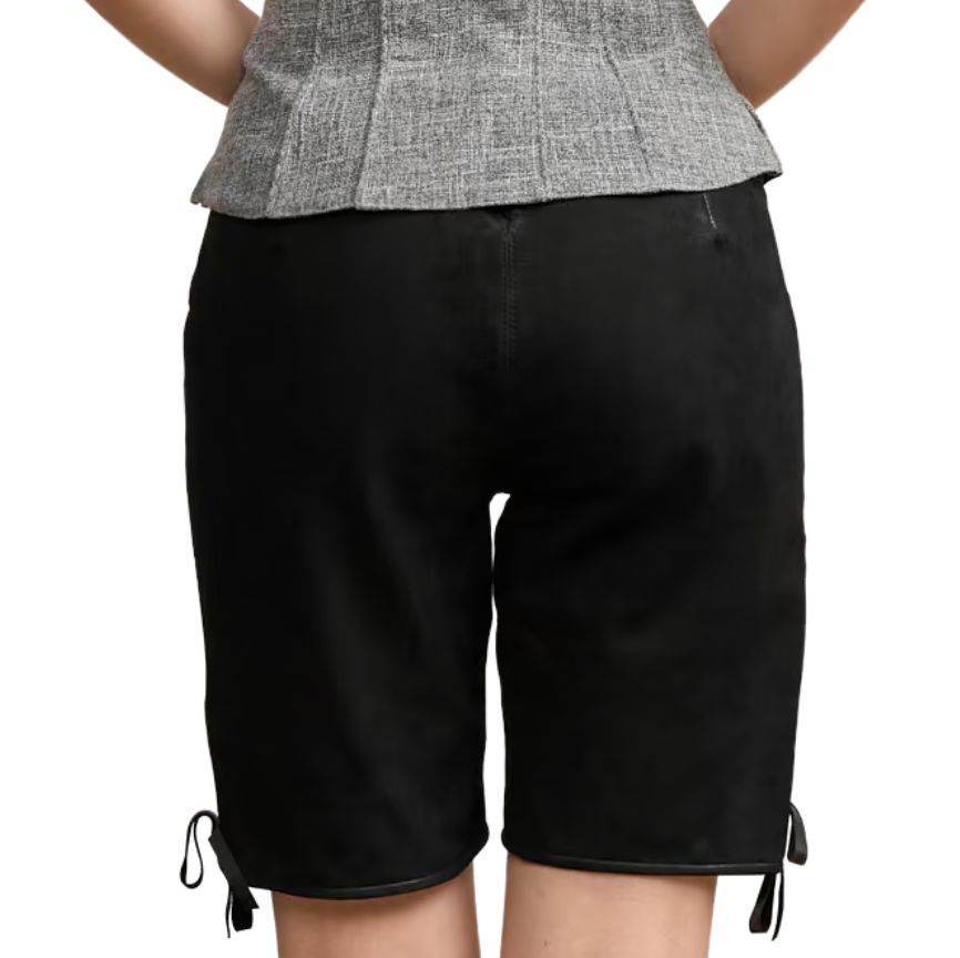 Back view of women’s black leather Bavarian-style shorts with a plain suede texture, subtle waistband tie, and bow-tied leg hems.