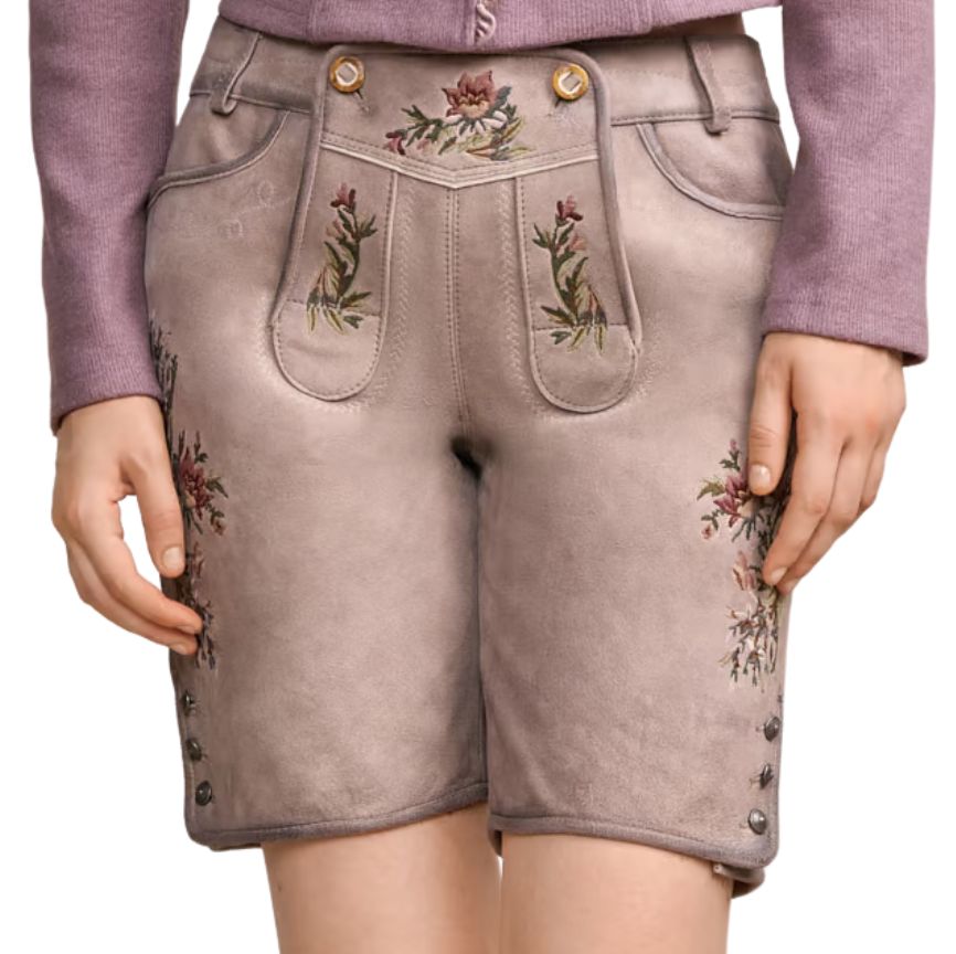 A frontal view of traditional beige suede lederhosen shorts for women, featuring colorful floral embroidery, side buttons on the hem, and decorative front panel stitching, worn with a purple sweater Heritage Rose Suede