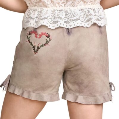 Back view of women’s traditional beige lederhosen shorts featuring embroidered pink floral heart design and ruffled hems, paired with a lace blouse.